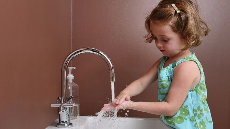 girl washes her hands to prevent parasite infection